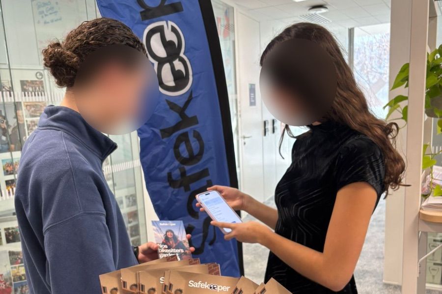 Stand Safekeeper sur le campus d'emlyon : une ambassadrice présente l'application sur son téléphone à une étudiante